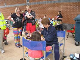 Face painters at work with mums watching 